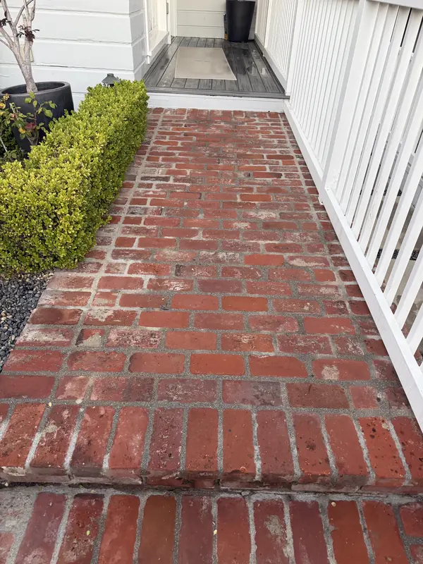 The same brick walkway clean and red after pressure washing